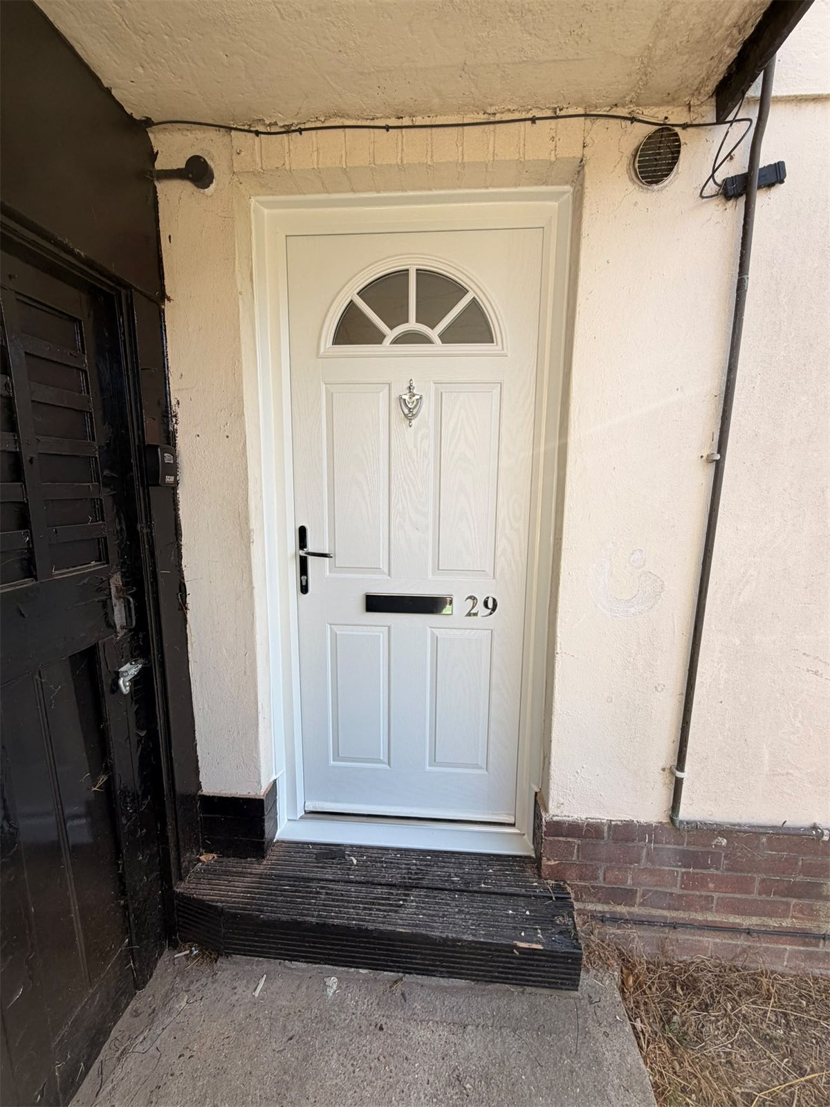 White composite door fitted in a rendered porch, London, fitted by Termopane Windows
