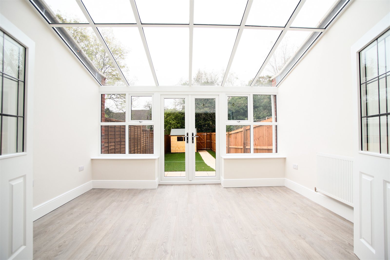 Bright lean-to conservatory with a glass roof, inside view (product photo)