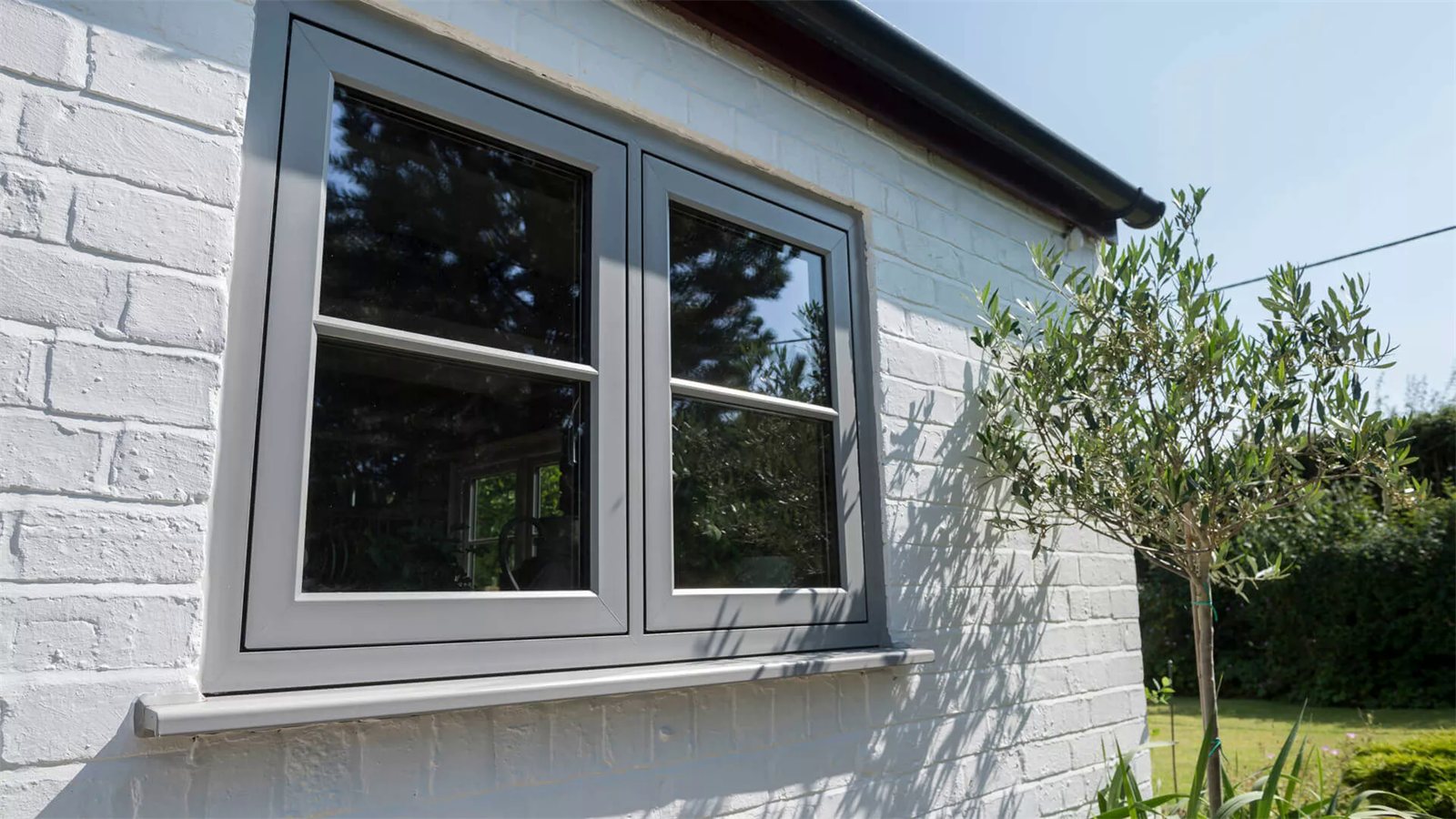 Grey flush sash windows on painted brick (product photo)