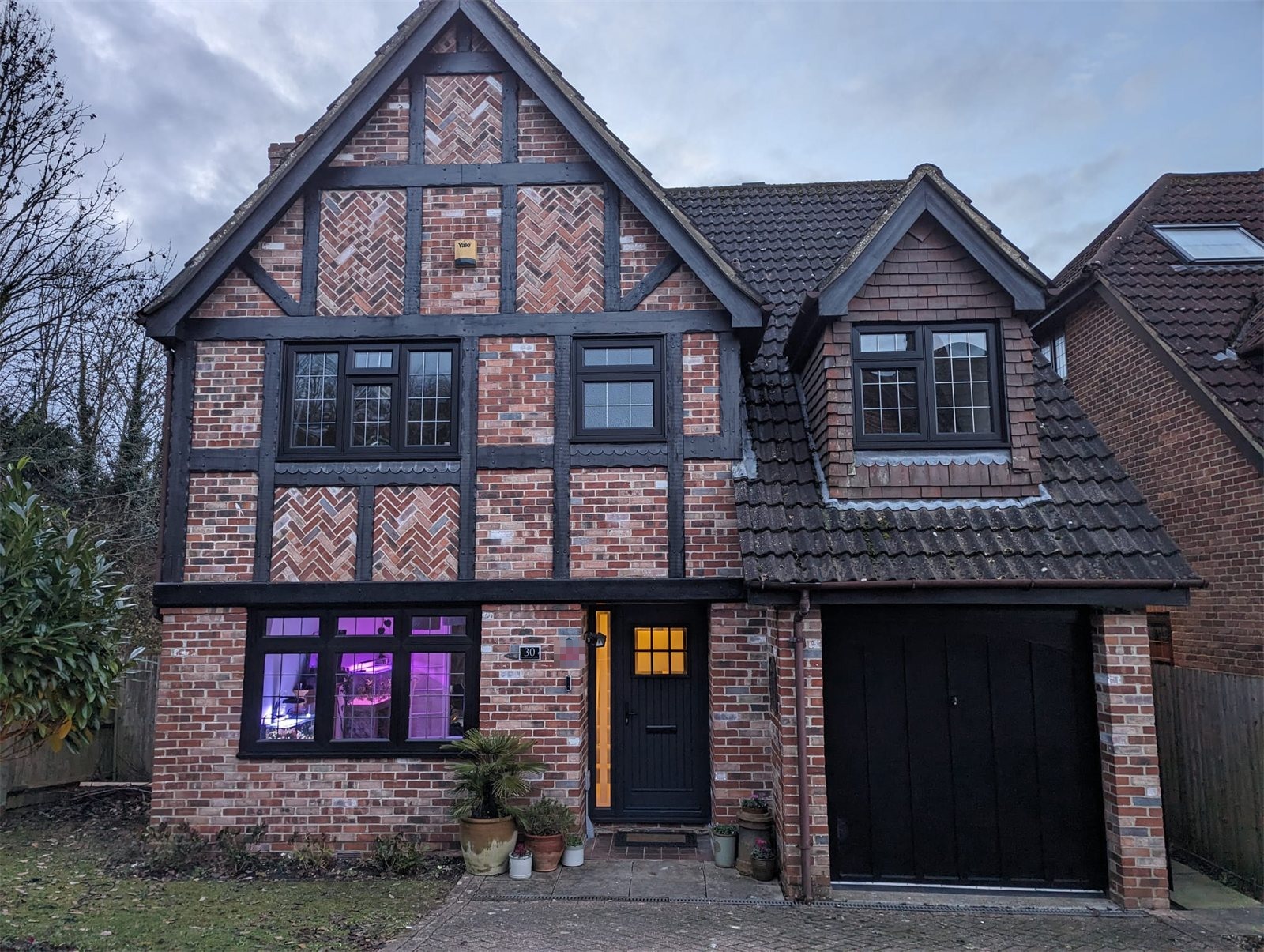 Black flush sash windows on a Tudor-style house (product photo)