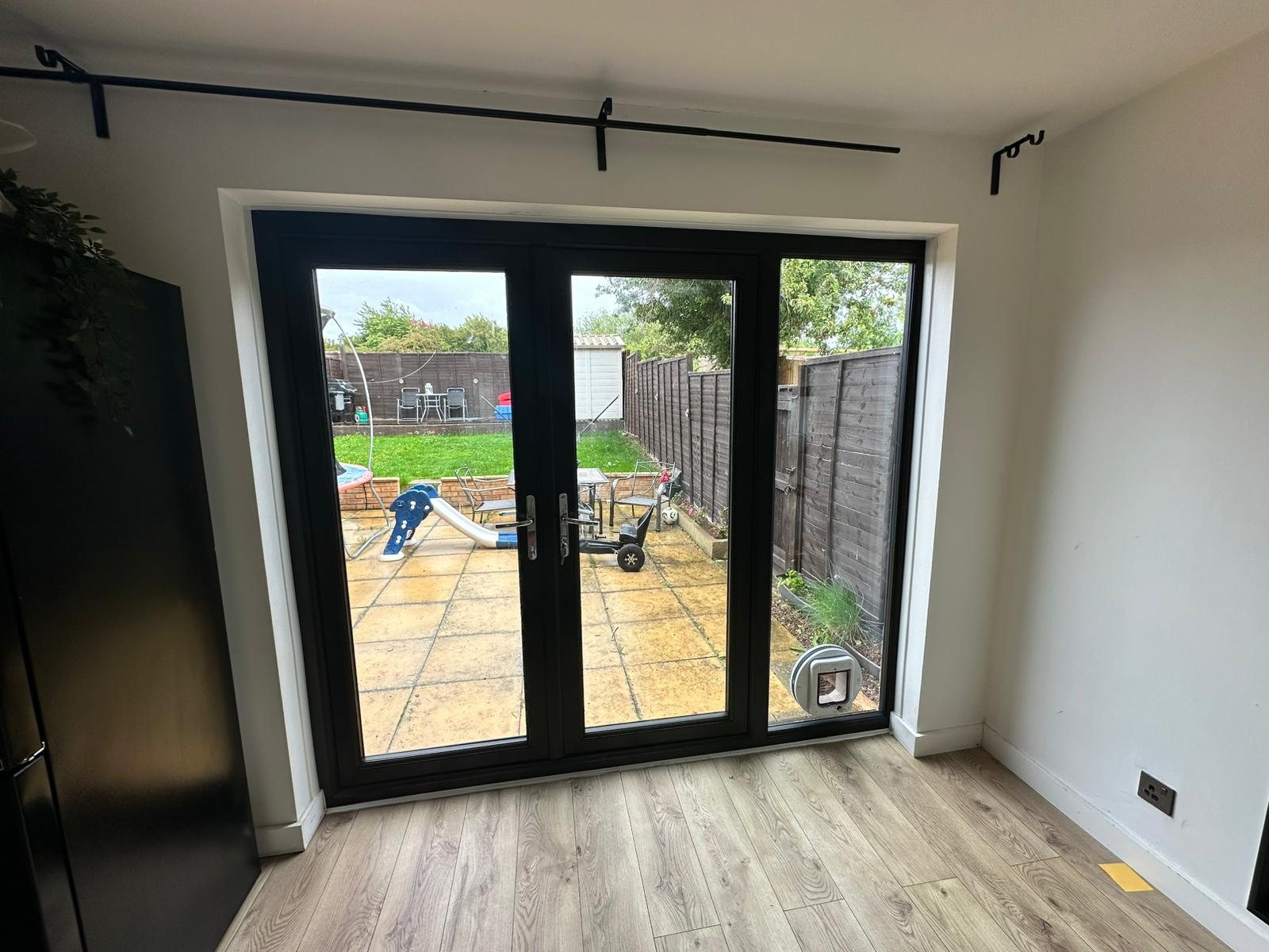 Black uPVC French doors with a cat flap, inside view, fitted by Termopane Windows