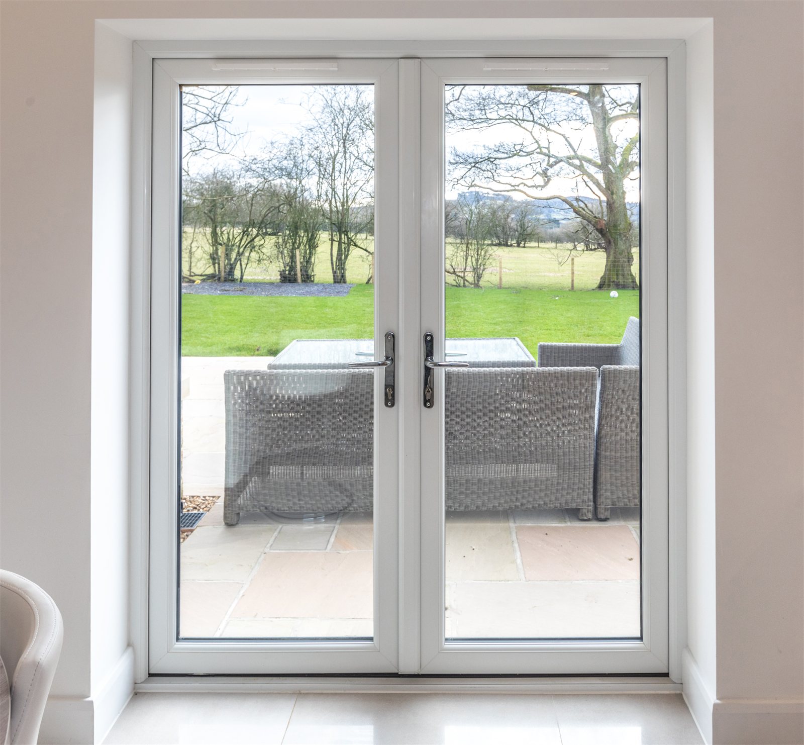 White uPVC French doors opening onto a garden (product photo)