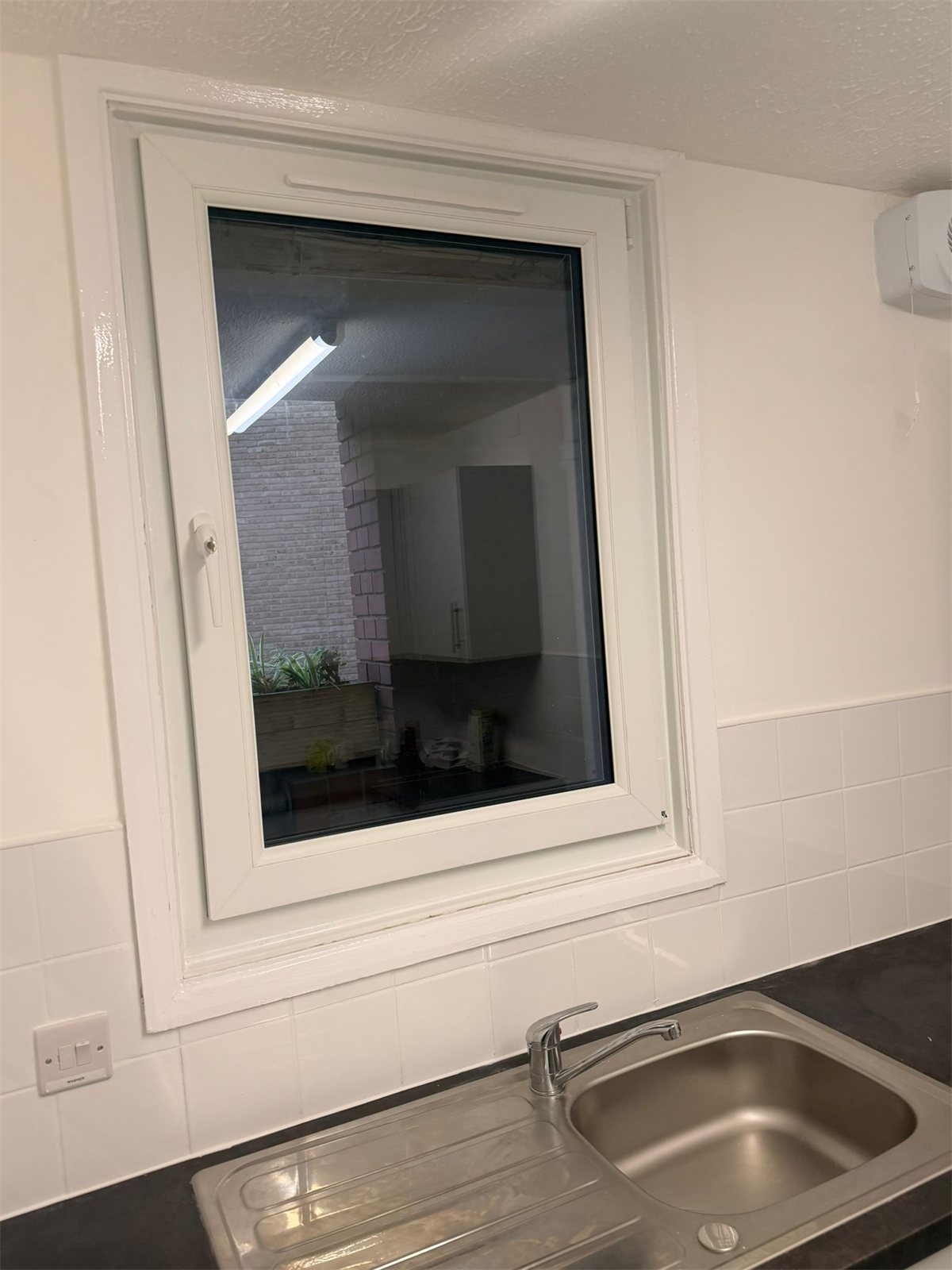 White tilt and turn window above a kitchen sink, London, fitted by Termopane Windows