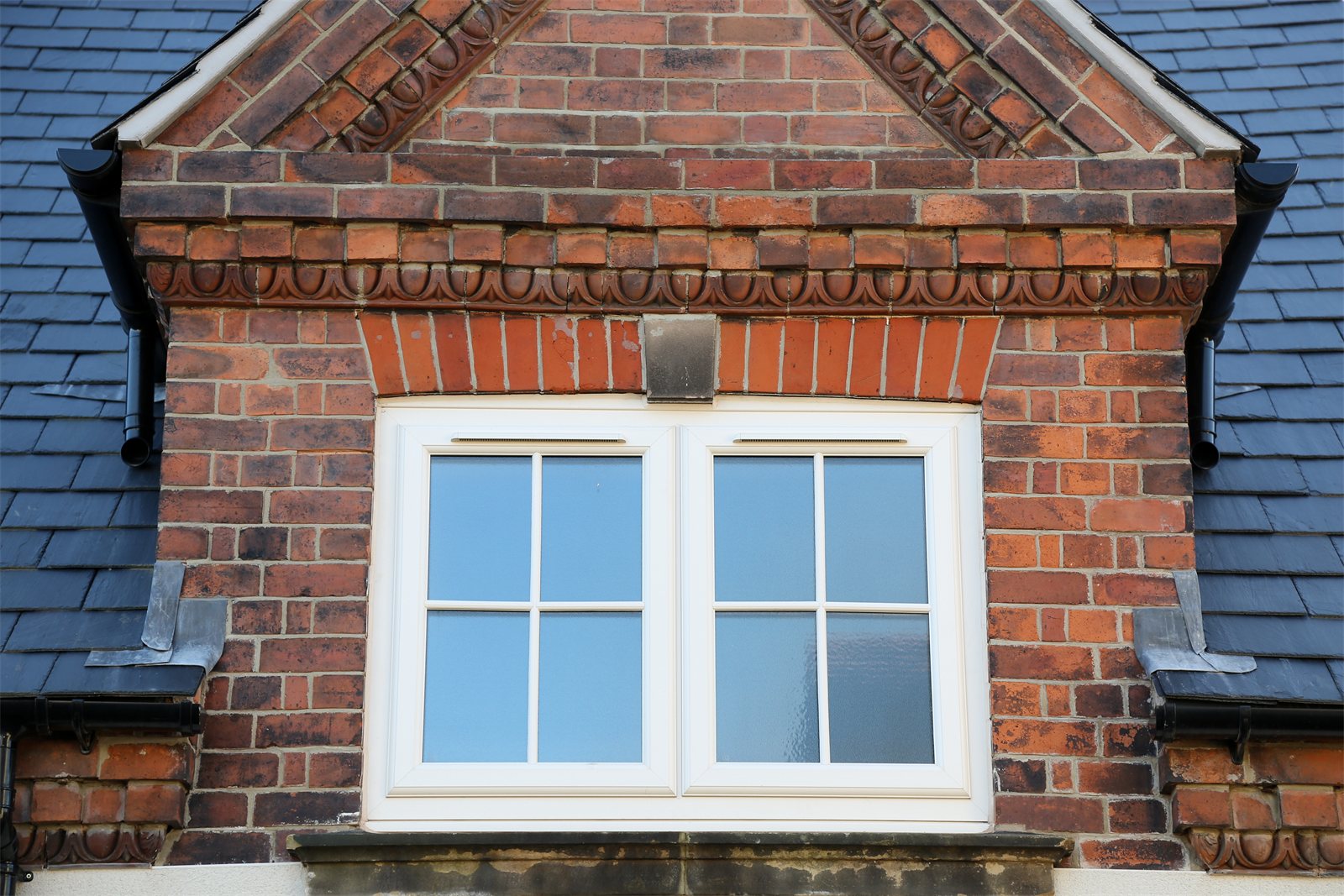 White uPVC casement window with Georgian bars in a brick gable (product photo)