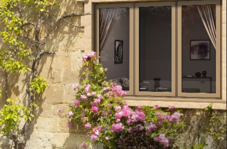 Aluminium window in a stone wall with climbing roses (product photo)